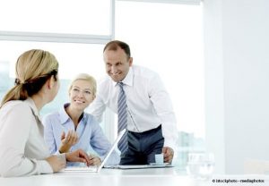 Dans un environnement de travail, un homme discute avec deux femmes