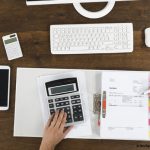 cahier de compte, calculette et smartphone avec deux mains