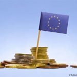 des pièces de monnaie et un drapeau européen