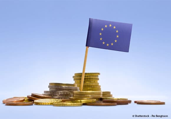 des pièces de monnaie et un drapeau européen