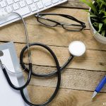 un clavier d'ordinateur, des lunettes, un stéthoscope