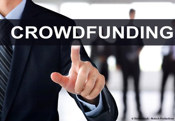 des pièces de monnaie dans une conserve de verre étiquetée "crowdfunding"