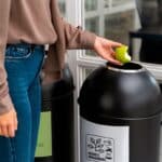 Employé de bureau utilisant un bac de tri design pour biodéchets, illustrant la valorisation des déchets organiques en entreprise.