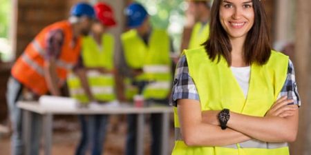 un travailleur etranger avec un casque et un gilet sur un chantier